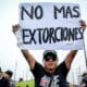 Un hombre sostiene un cartel durante una jornada de paro de transportadores, este jueves, en la ciudad de Lima (Perú). EFE/STR