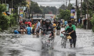 Víctimas de las inundaciones de Sri Lanka caminan por una carretera inundada después de fuertes lluvias en el suburbio de Colombo, Sri Lanka, este lunes. EFE/ Chamila Karunarathne