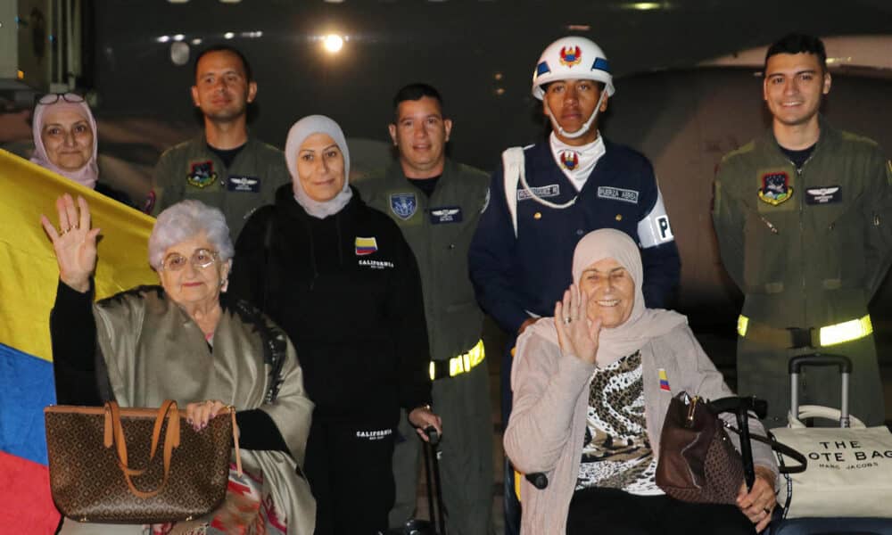 Fotografía cedida por la Fuerza Aérea Colombiana (FAC) que muestra a un grupo de ciudadanos colombianos que posa junto a integrantes de la FAC luego de su llegada en la madrugada de este jueves a Bogotá (Colombia). EFE/ Fuerza Aérea Colombiana