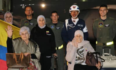 Fotografía cedida por la Fuerza Aérea Colombiana (FAC) que muestra a un grupo de ciudadanos colombianos que posa junto a integrantes de la FAC luego de su llegada en la madrugada de este jueves a Bogotá (Colombia). EFE/ Fuerza Aérea Colombiana