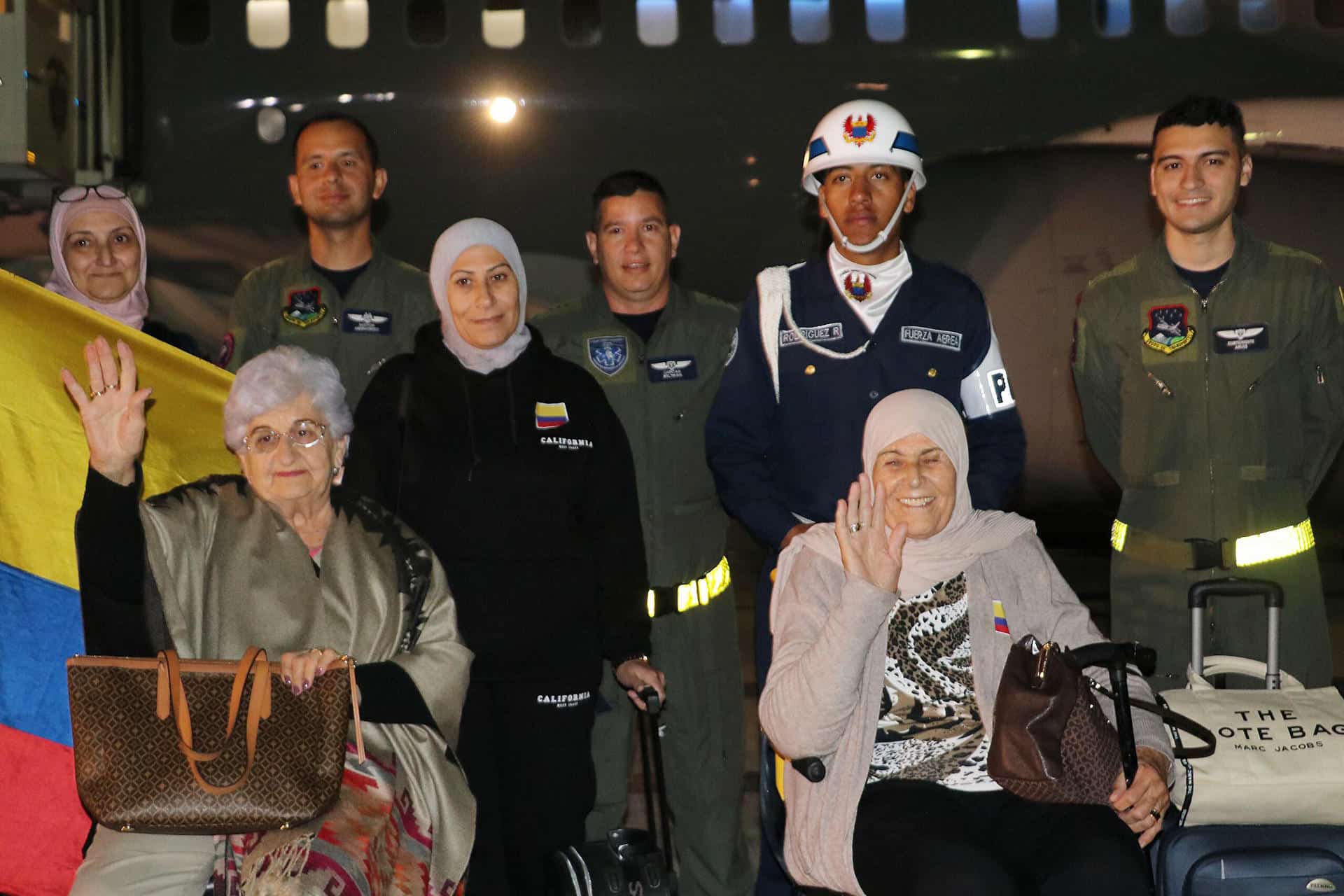 Fotografía cedida por la Fuerza Aérea Colombiana (FAC) que muestra a un grupo de ciudadanos colombianos que posa junto a integrantes de la FAC luego de su llegada en la madrugada de este jueves a Bogotá (Colombia). EFE/ Fuerza Aérea Colombiana