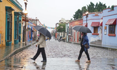 Imagen de archivo de dos personas que se protegen de la lluvia en el estado de Oaxaca (México). EFE/Daniel Ricardez