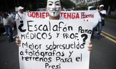 Un manifestante sostiene un cartel en una marcha este sábado en San Salvador (El Salvador). EFE/ Rodrigo Sura