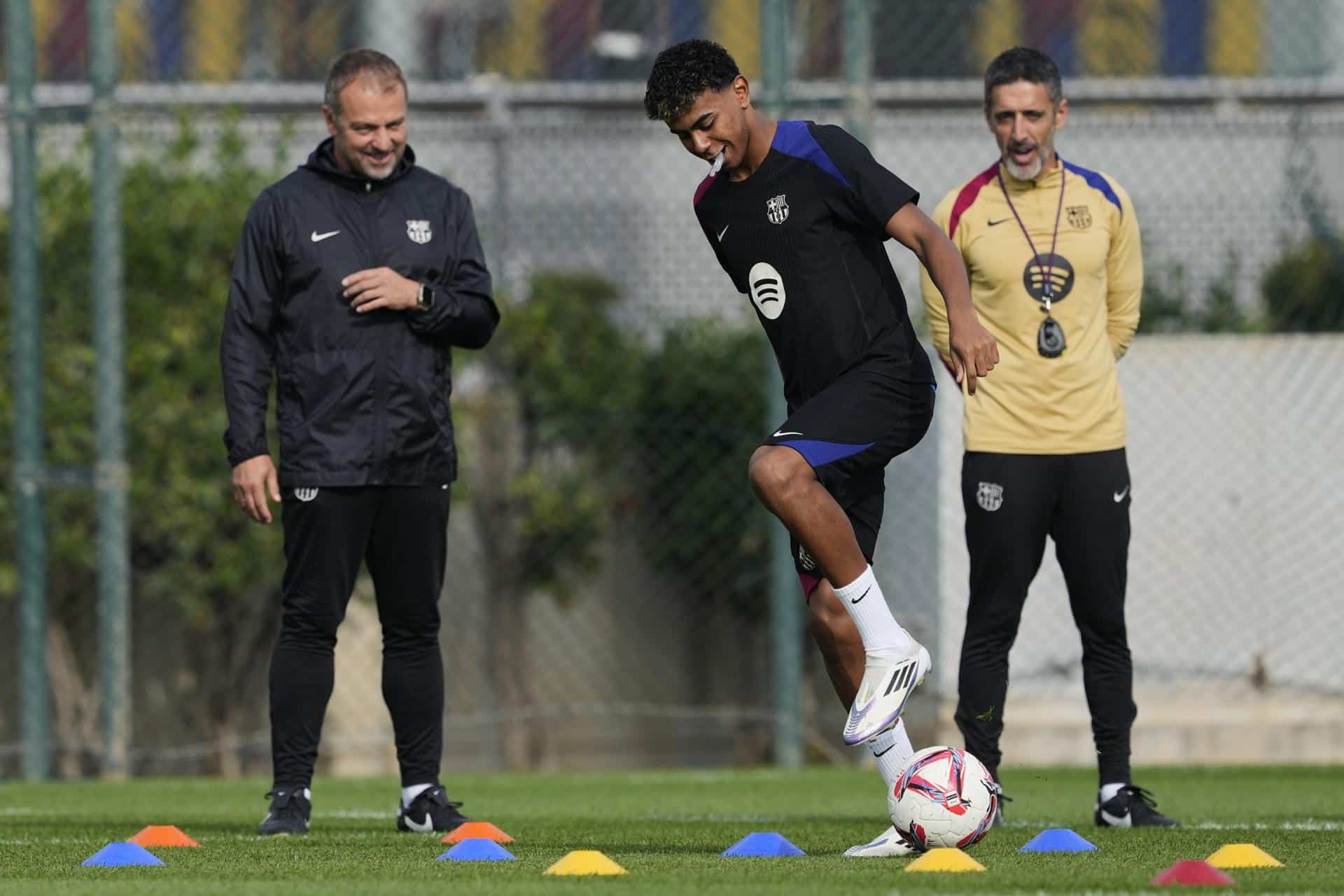 El entrenador del Barcelona Hansi Flick (iz) observa a Lamine Yamal durante el entrenamiento de este viernes. EFE/Alejandro García.