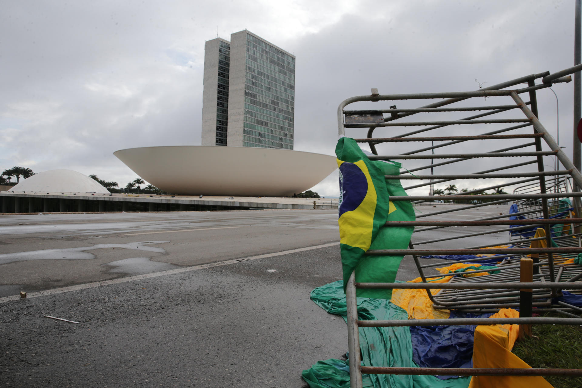 Fotografía de archivo del 9 de enero de 2023 de vallas destrozadas en las afueras del Palacio de Planalto, con el Congreso de fondo, luego de que manifestantes bolsonaristas se tomaran en la víspera la Plaza de los Tres Poderes para invadir los edificios gubernamentales, en Brasilia (Brasil).EFE/ André Coelho