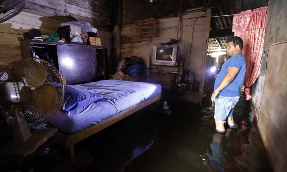 Un hombre revisa sus pertenencias al interior de una casa afectada por las inundaciones este miércoles, en Batabanó (Cuba). EFE/ Ernesto Mastrascusa