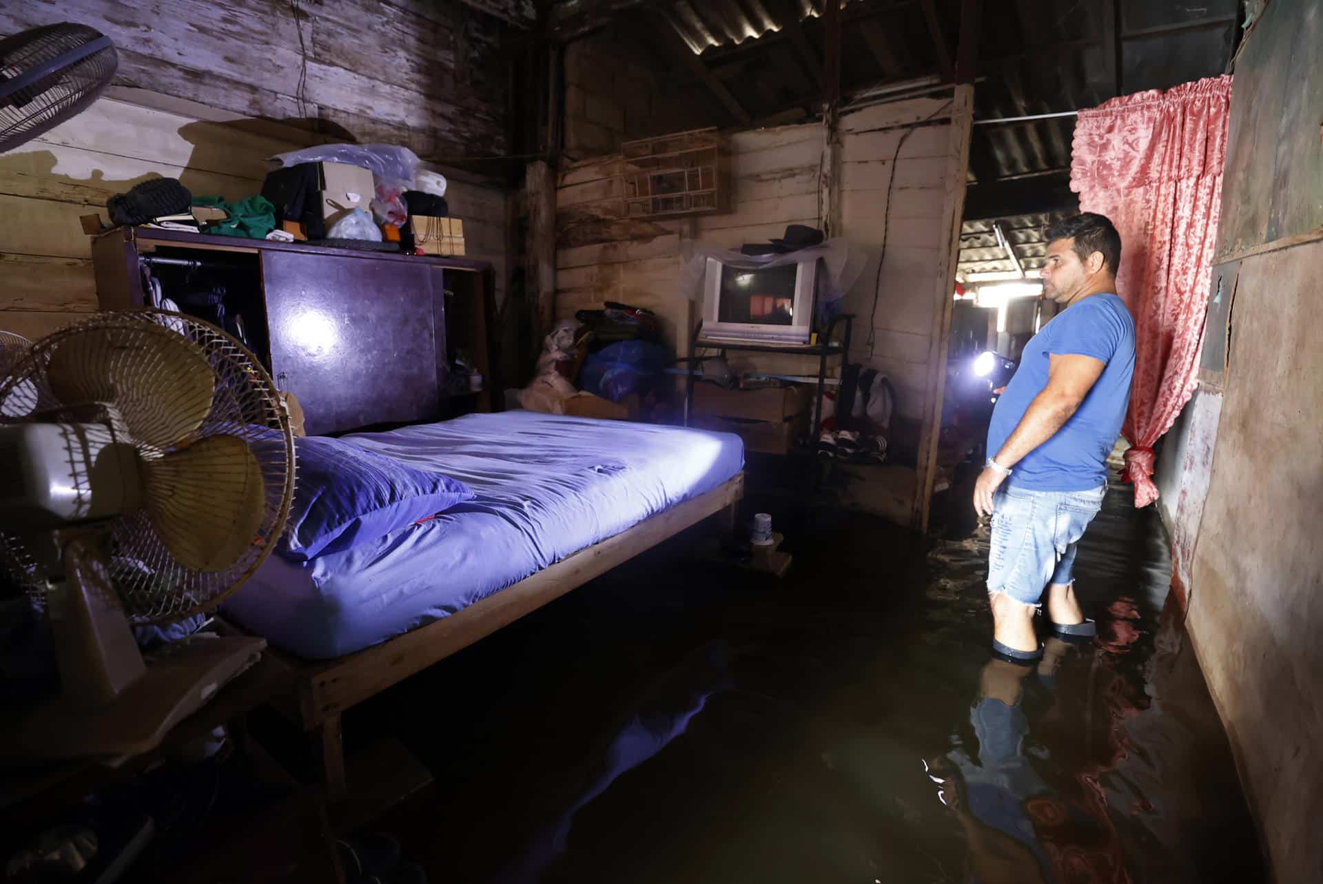 Un hombre revisa sus pertenencias al interior de una casa afectada por las inundaciones este miércoles, en Batabanó (Cuba). EFE/ Ernesto Mastrascusa