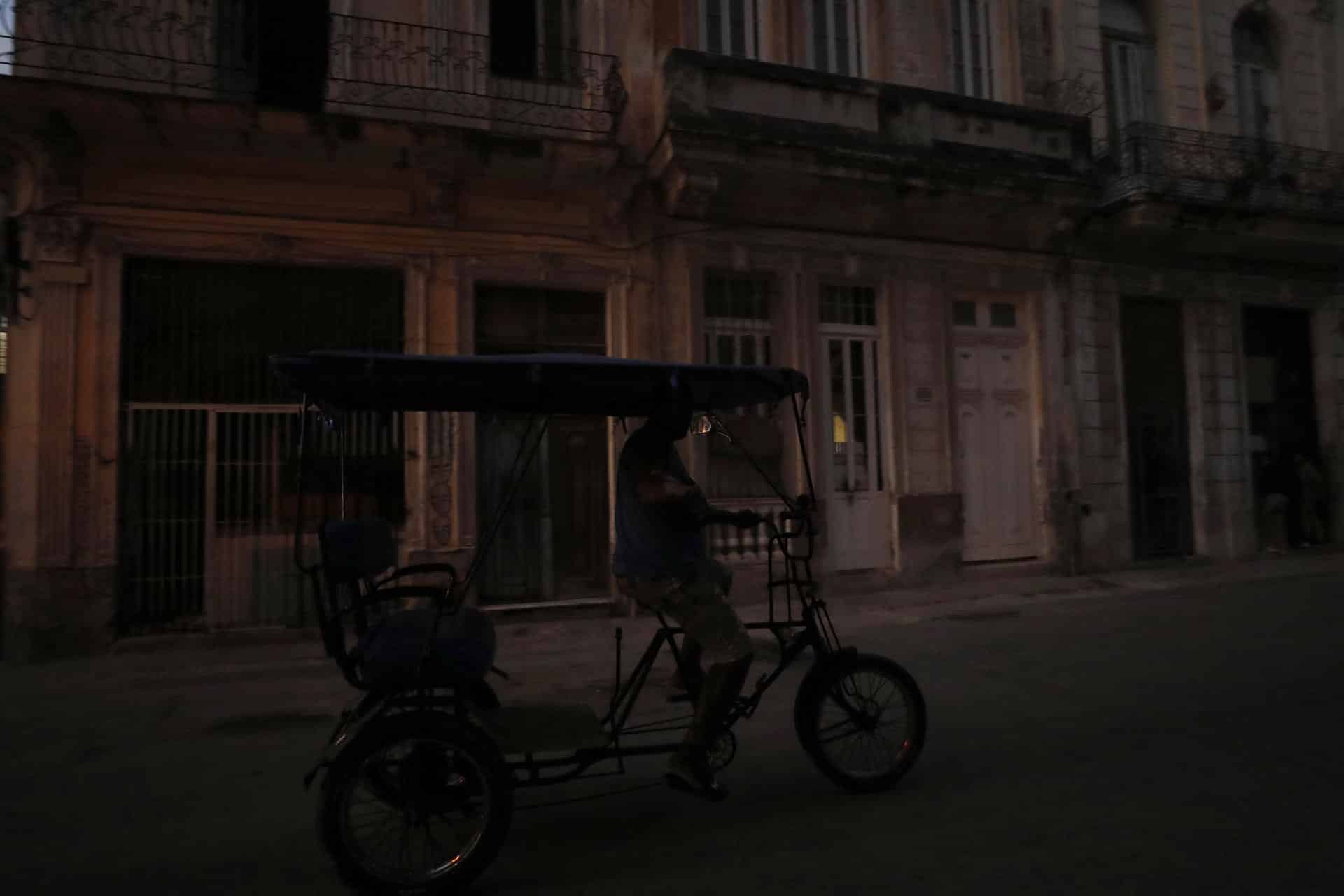 Fotografía de archivo de un bicitaxi que transita por una calle poco iluminada el 26 de marzo de 2024, en La Habana (Cuba). EFE/Yander Zamora