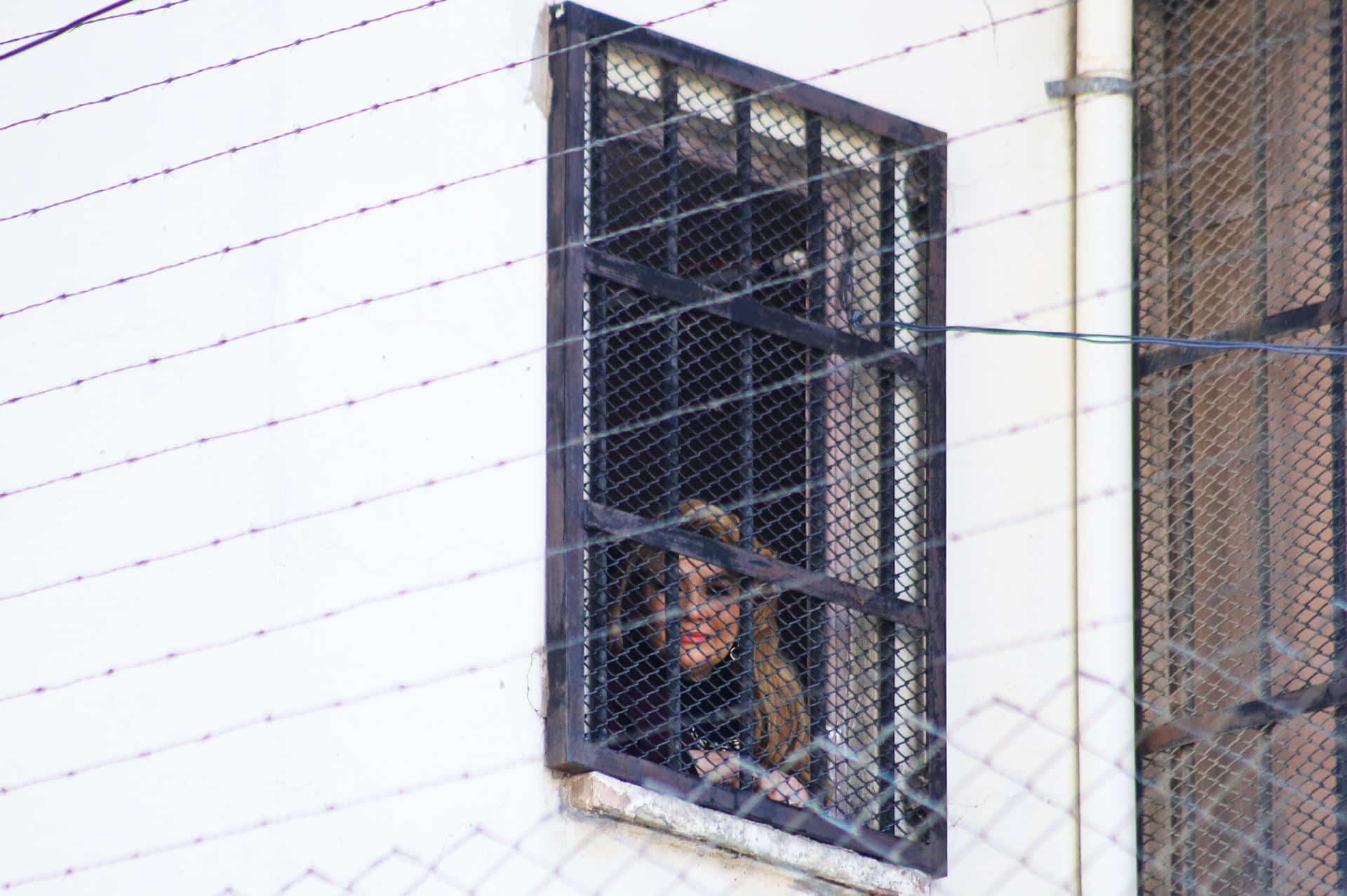 La expresidenta interina de Bolivia, Jeanine Añes (20019-2020), observa desde una ventana este lunes, en el centro de orientación femenina de Miraflores, en La Paz (Bolivia). EFE/ Gabriel Márquez