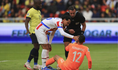 Roberto Junior Fernández (abajo) portero de Paraguay recibe atención luego de una falta en un partido de las eliminatorias sudamericanas para el Mundial de 2026. EFE/ José Jácome