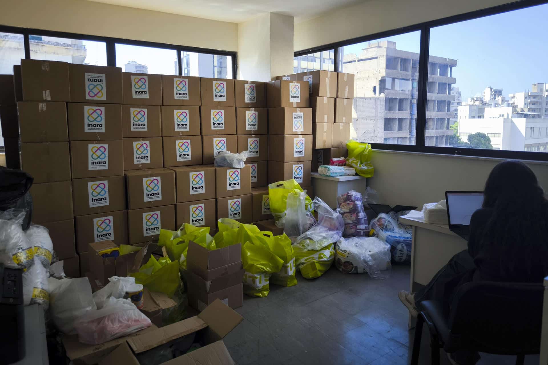 Cajas de comida apiladas en la oficina de la ONG Inara, en Beirut, para ser repartidas a centros de desplazados. Con el invierno a la vuelta de la esquina, muchos de los cientos de miles de desplazados por los ataques israelíes en el Líbano siguen a la intemperie en sus coches o tiendas de campaña sin saber dónde ir. EFE/ Isaac J. Martín