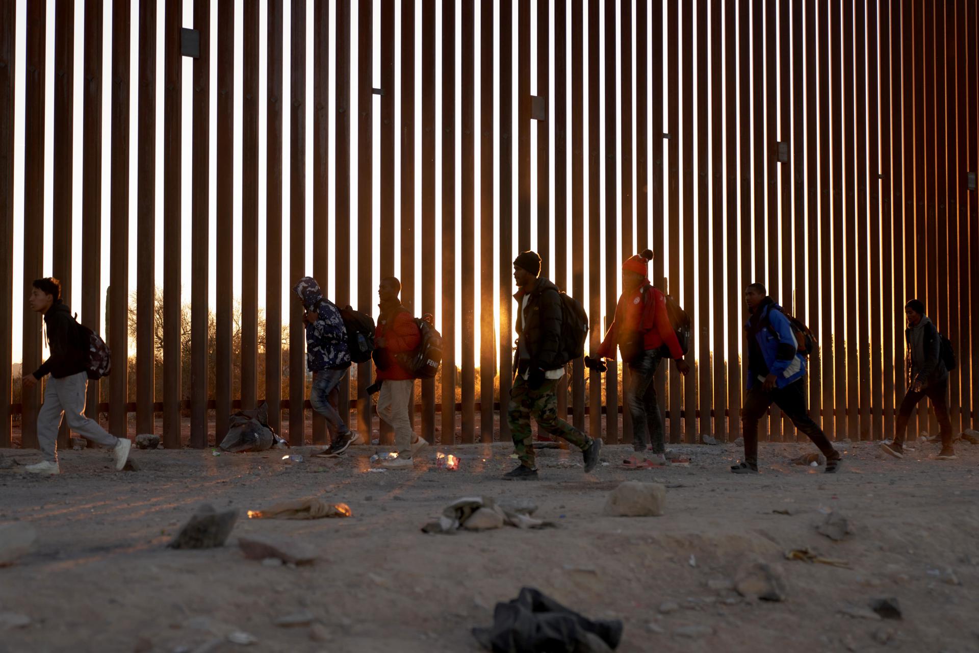 Fotografía de archivo de migrantes caminando a lo largo del muro fronterizo de EE. UU. en Arizona. CENA EFE/ALLISON