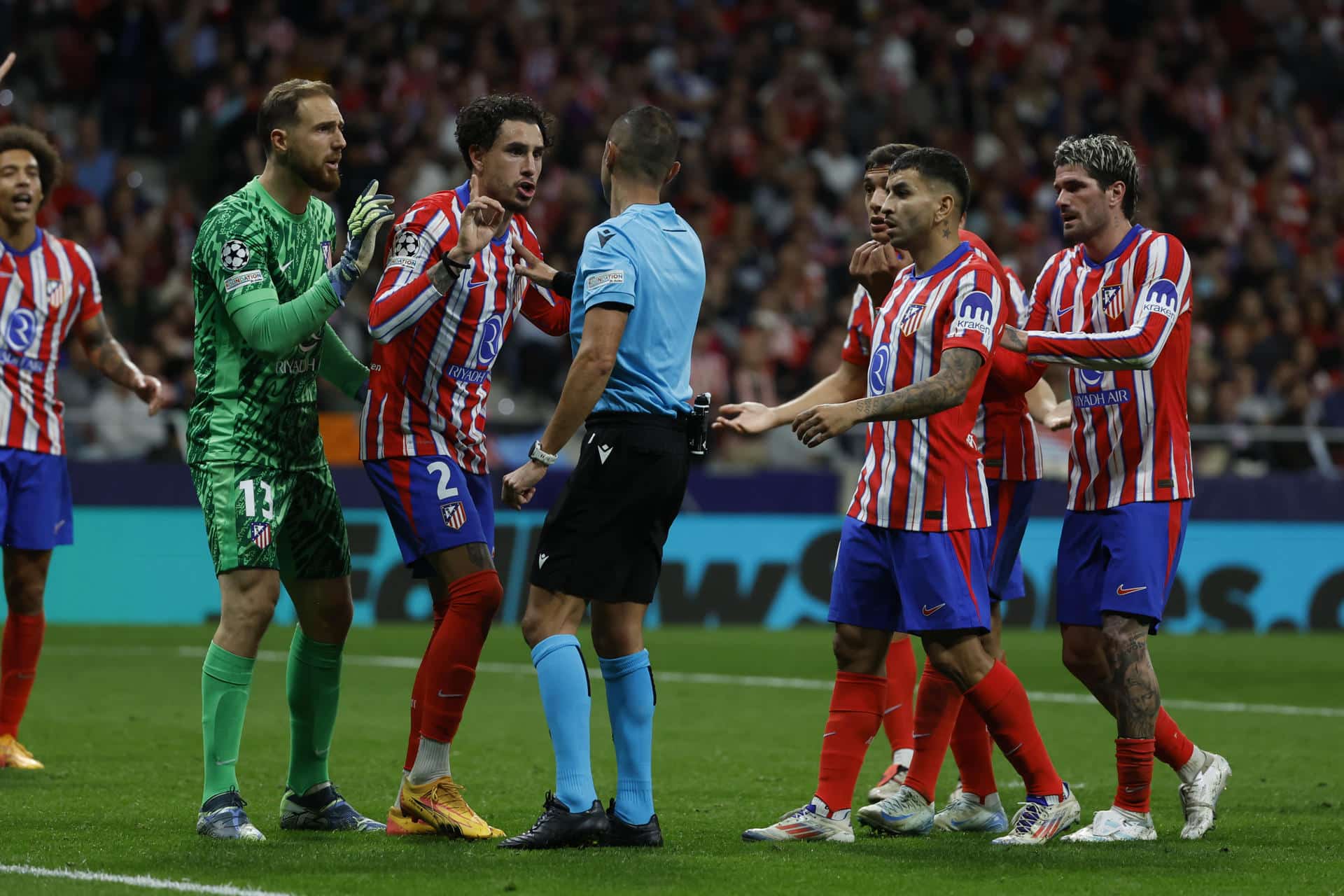 Los jugadores del Atlético protestan al árbitro, Marco Guida, tras señalar el penalti. EFE/ Juanjo Martin