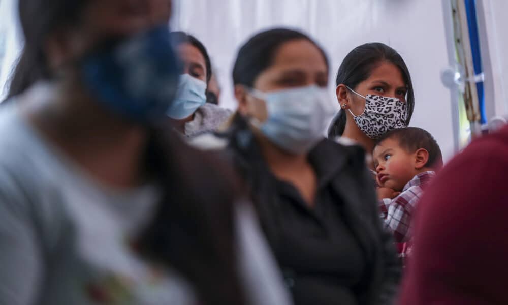 Fotografía de archivo de una mujer que escucha con su hijo en brazos una charla sobre nutrición en Ecuador. EFE/José Jácome