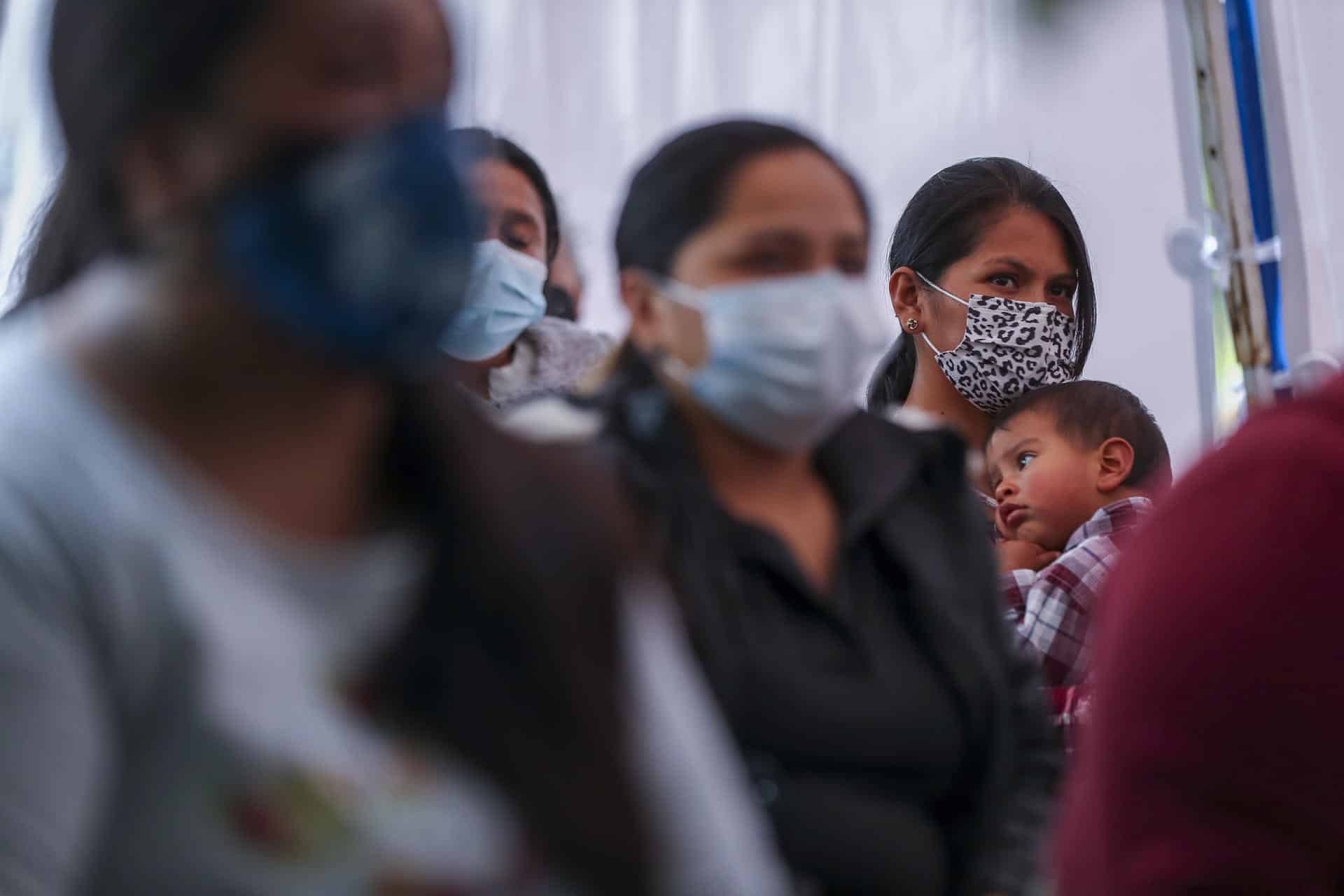 Fotografía de archivo de una mujer que escucha con su hijo en brazos una charla sobre nutrición en Ecuador. EFE/José Jácome