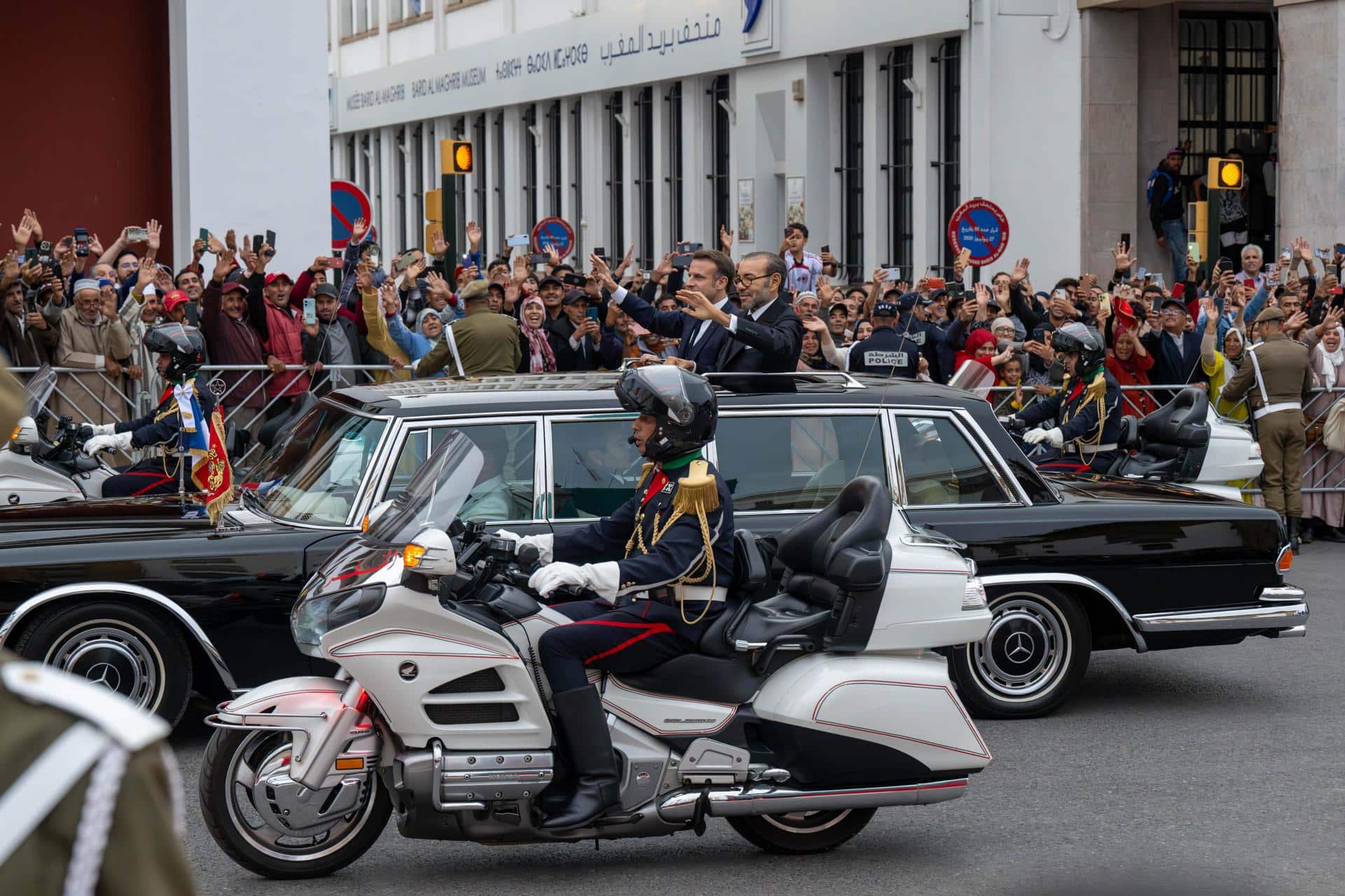 El rey de Marruecos, Mohammed VI (centro-derecha), y el presidente francés, Emmanuel Macron (centro-izquierda), saludan a la multitud mientras viajan en un automóvil abierto por una carretera en Rabat, Marruecos, el 28 de octubre de 2024. El presidente francés, Emmanuel Macron, se encuentra en Rabat para una visita de Estado de tres días por invitación del rey Mohammed VI. La visita pretende marcar una nueva ambición para los próximos 30 años en la relación franco-marroquí, según el Palacio del Elíseo. (Francia, Marruecos) EFE/EPA/JALAL MORCHIDI