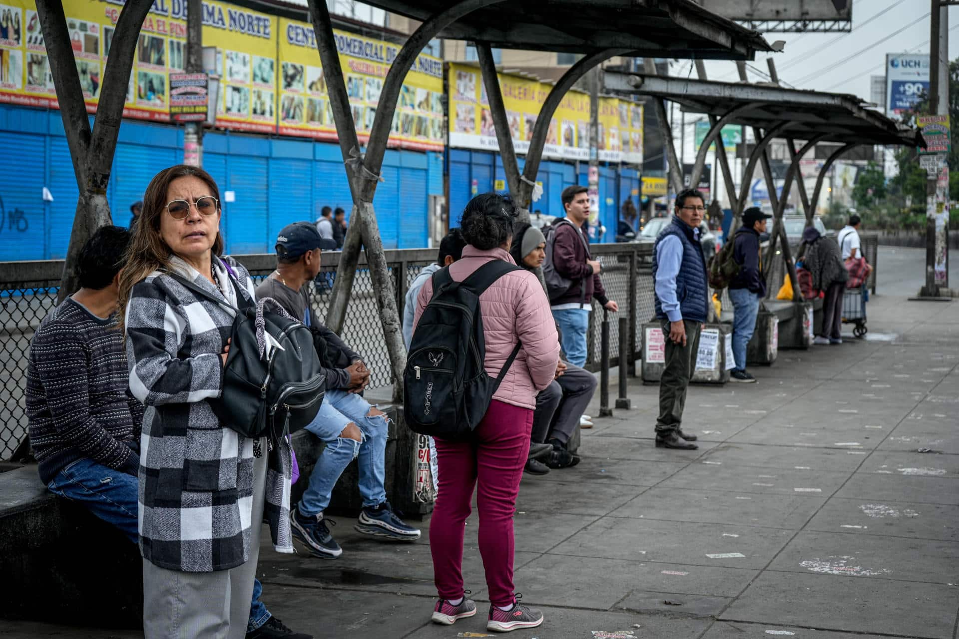 Personas esperan en un paradero de buses durante una jornada de paro de transportadores, este jueves,en la ciudad de Lima (Perú). EFE/ John Reyes Mejia