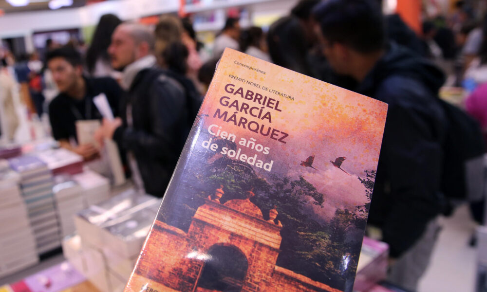 Fotografía del 30 de abril de 2017 de asistentes a la XXX Feria Internacional del Libro de Bogotá (Filbo) mientras observan el libro "Cien Años de Soledad", del escritor colombiano Gabriel García Márquez, en Bogotá (Colombia). EFE/Mauricio Dueñas