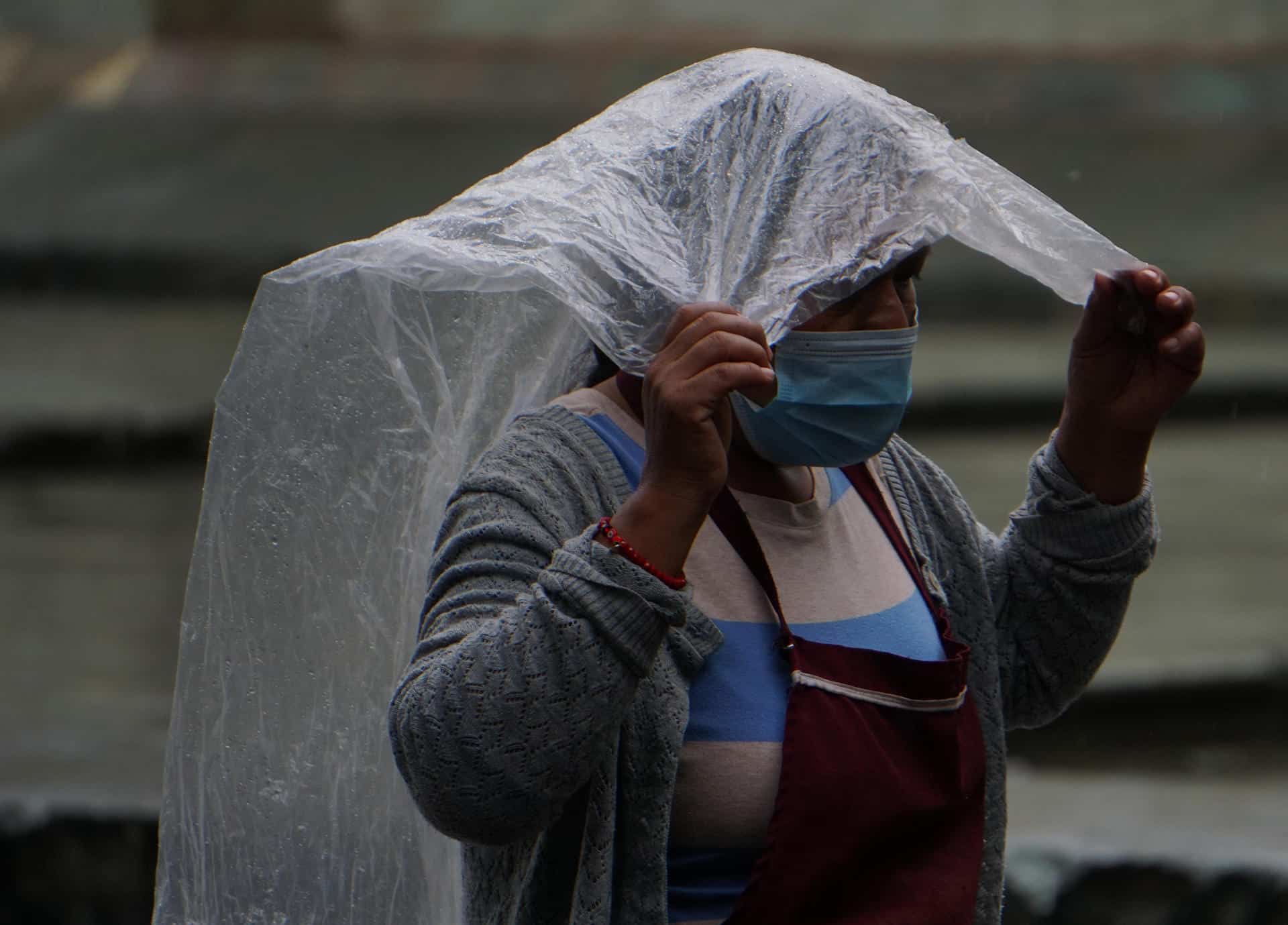 Una mujer se protege de la lluvia en el estado de Oaxaca (México). Archivo. EFE/Daniel Ricardez