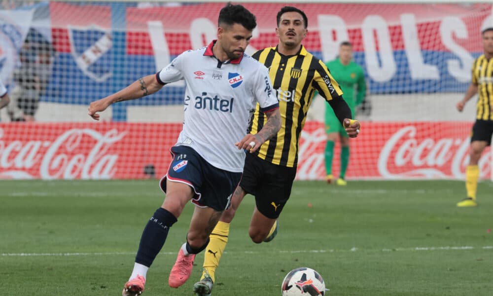 Gabriel Báez (i) de Nacional disputa un balón con Eduardo Darias de Peñarol en un partido de la fecha 6 del Torneo Clausura de la Primera División de Uruguay. EFE/ Gastón Britos