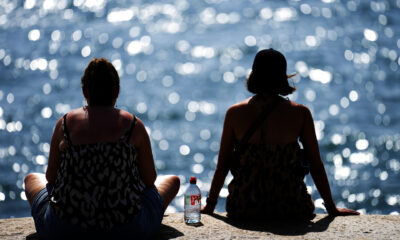 Dos personas observan el mar en una jornada de intenso calor, en una imagen de archivo. EFE/Alejandro García