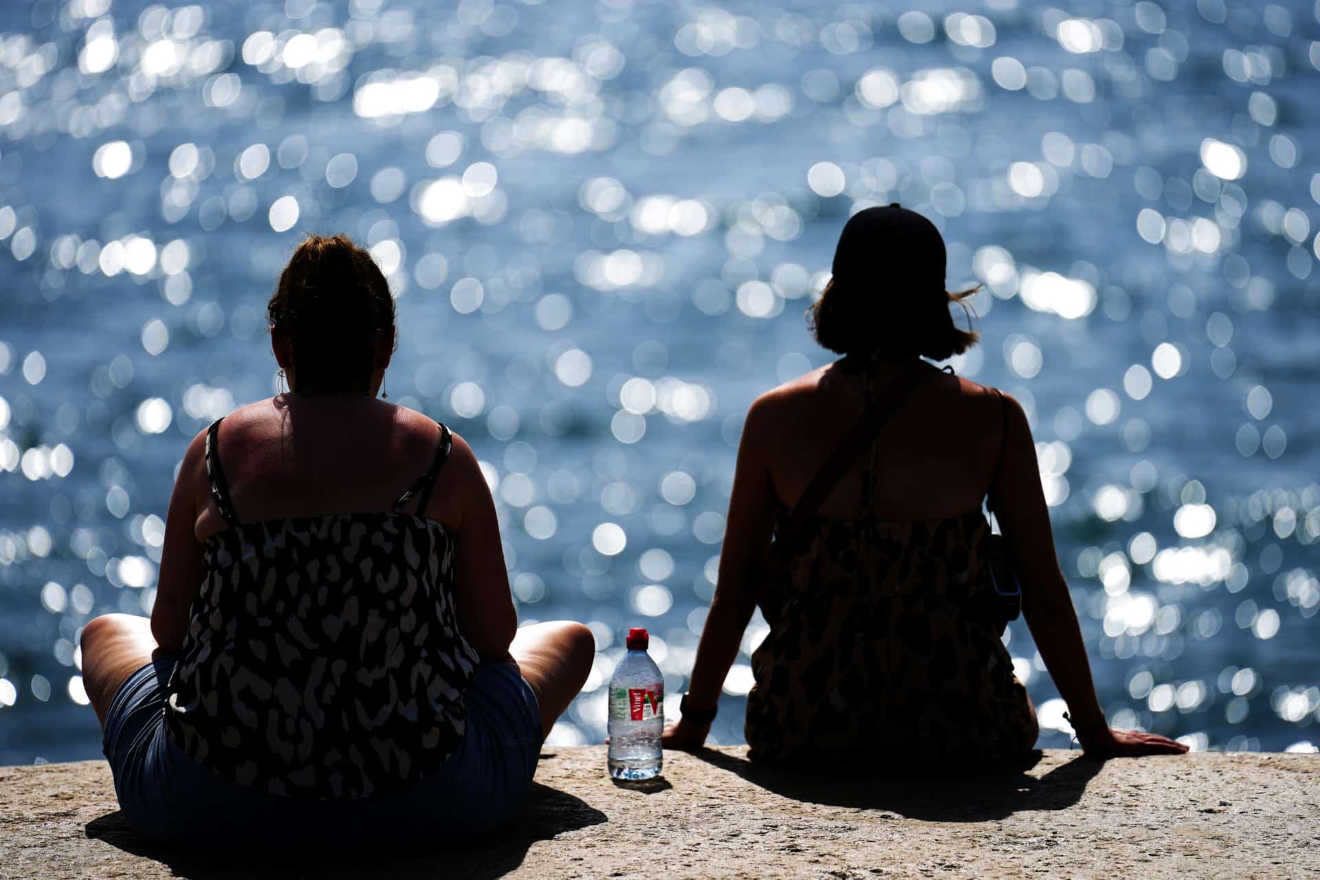 Dos personas observan el mar en una jornada de intenso calor, en una imagen de archivo. EFE/Alejandro García