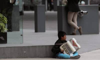 Fotografía de archivo fechada el 13 de agosto de 2015 que muestra a un niño mientras toca el acordeón para ganar un sustento, en una calle de la Ciudad de México (México). Archivo. EFE/Alex Cruz