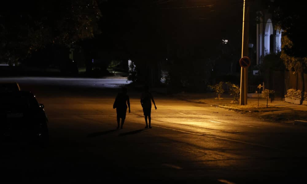 Fotografía de archivo de personas que caminan por una calle con poca iluminación en La Habana (Cuba). EFE/Ernesto Mastrascusa