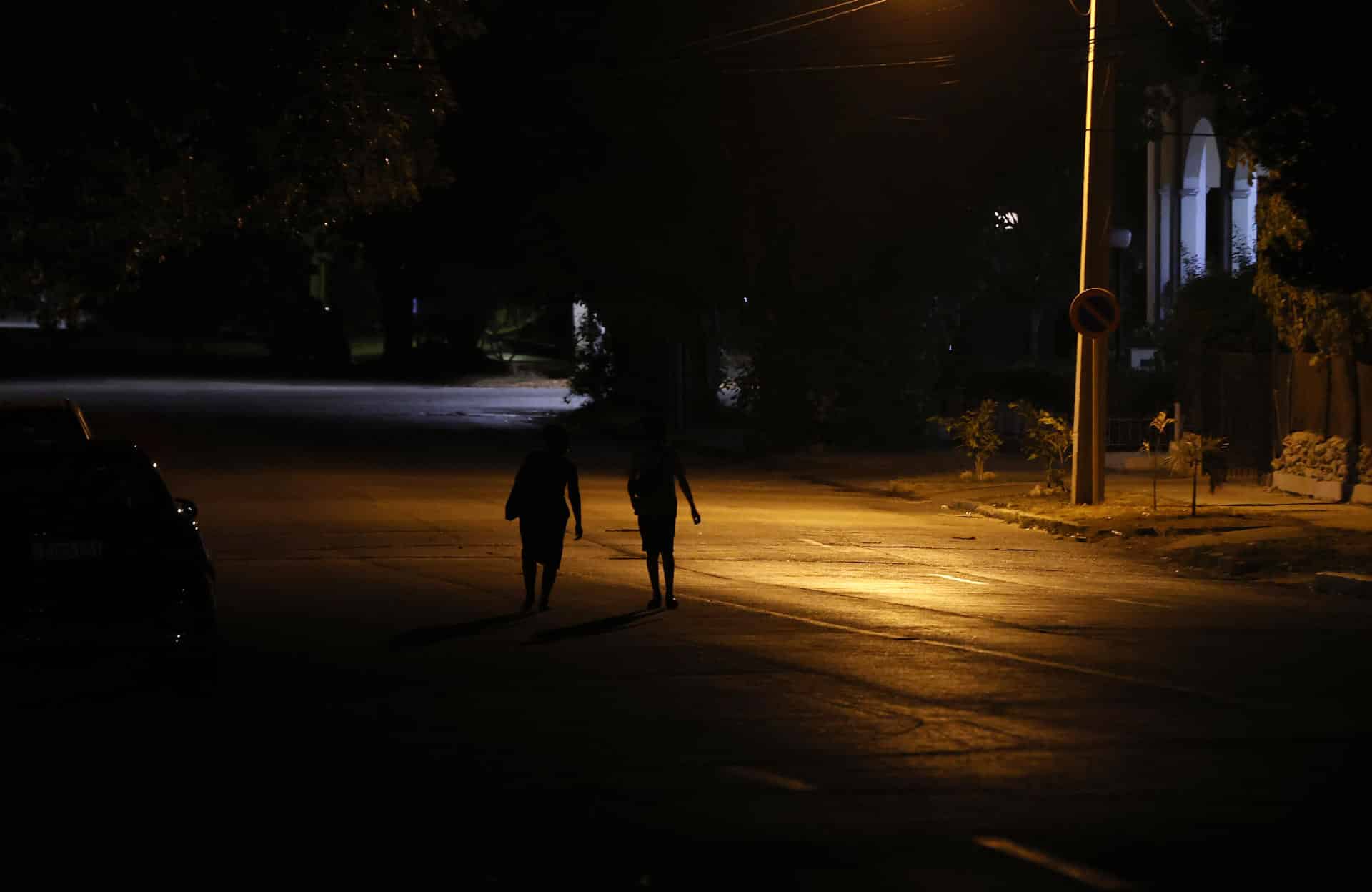 Fotografía de archivo de personas que caminan por una calle con poca iluminación en La Habana (Cuba). EFE/Ernesto Mastrascusa