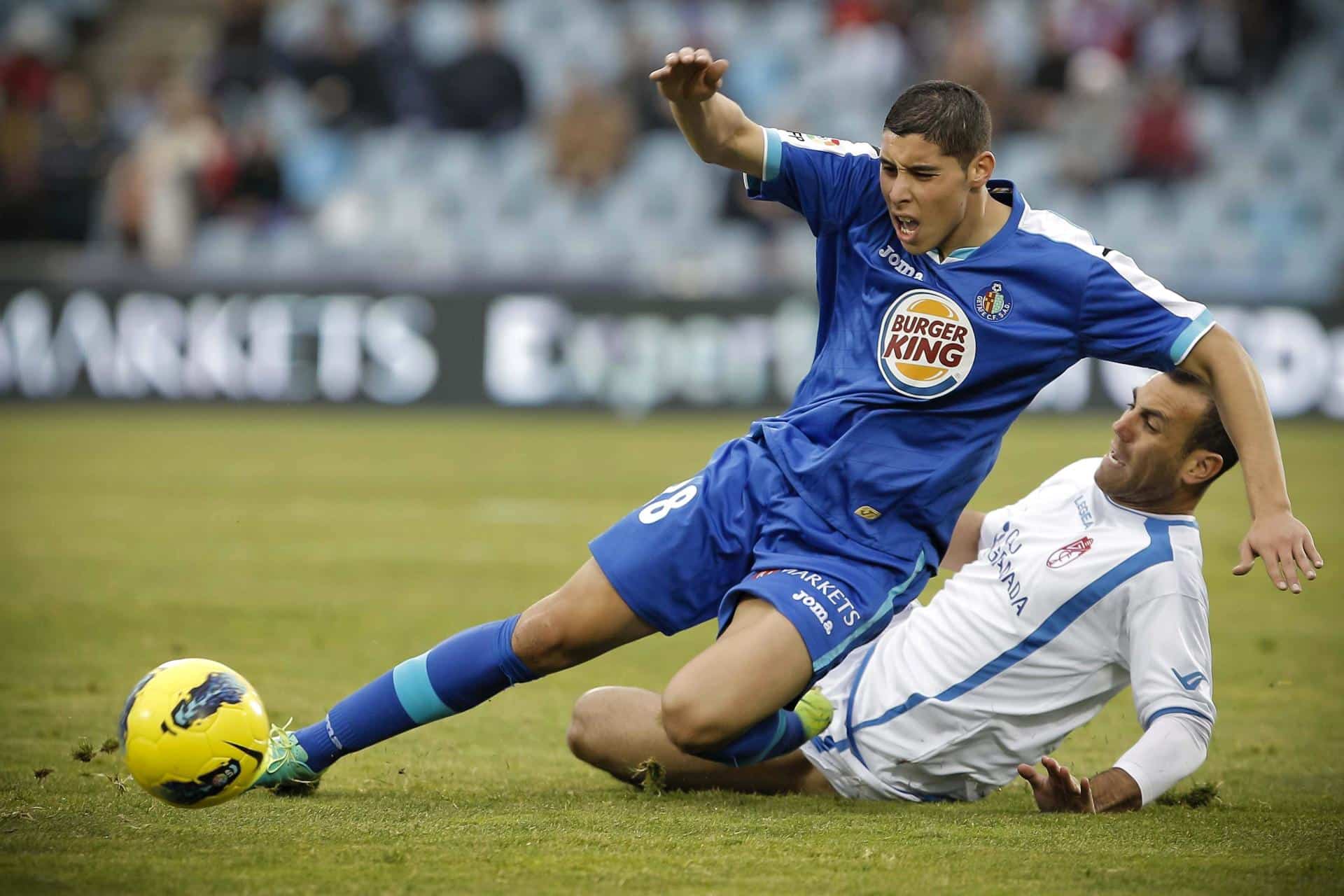 El centrocampista marroquí del Getafe Abdel Barrada (i) lucha por un balón con el jugador del Granada Moisés Hurtado, en una foto de archivo. EFE/Emilio Naranjo