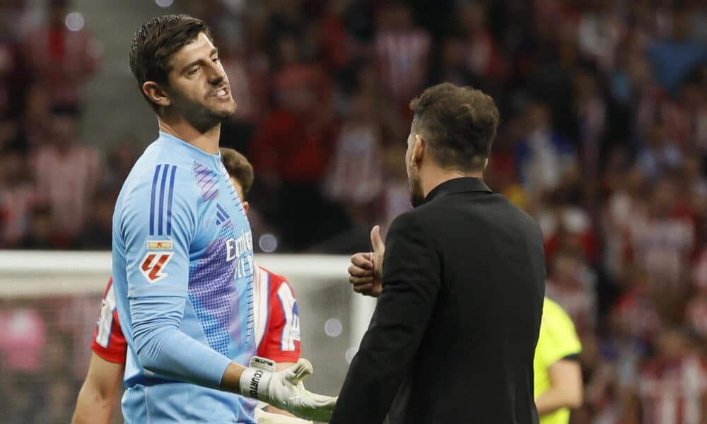 El portero del Real Madrid Thibaut Courtois (i) conversa con el entrenador del Atlético, Diego Simeone, durante en el estadio Civitas Metropolitano. EFE/Ballesteros