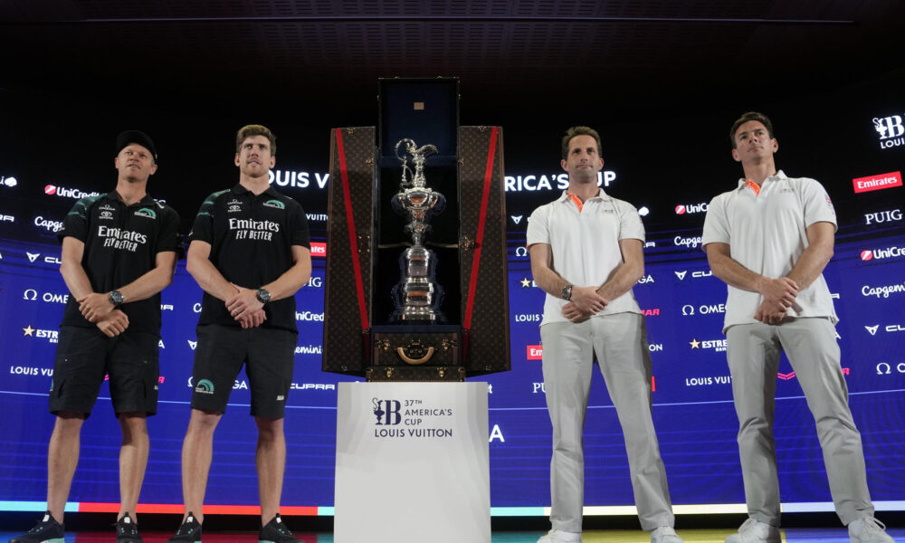 Los timoneles del equipo defensor Team New Zealand, Peter Burling (2i) y Nathan Outteridge (i), y del equipo desafiante INEOS Britannia, Ben Ainslie (2d) y Dylan Fletcher (d), posan ante la Copa de las cien guineas, durante la rueda de prensa de presentación de la Copa del América 2024 que mañana comenzará a disputarse en las aguas de Barcelona. EFE/Enric Fontcuberta