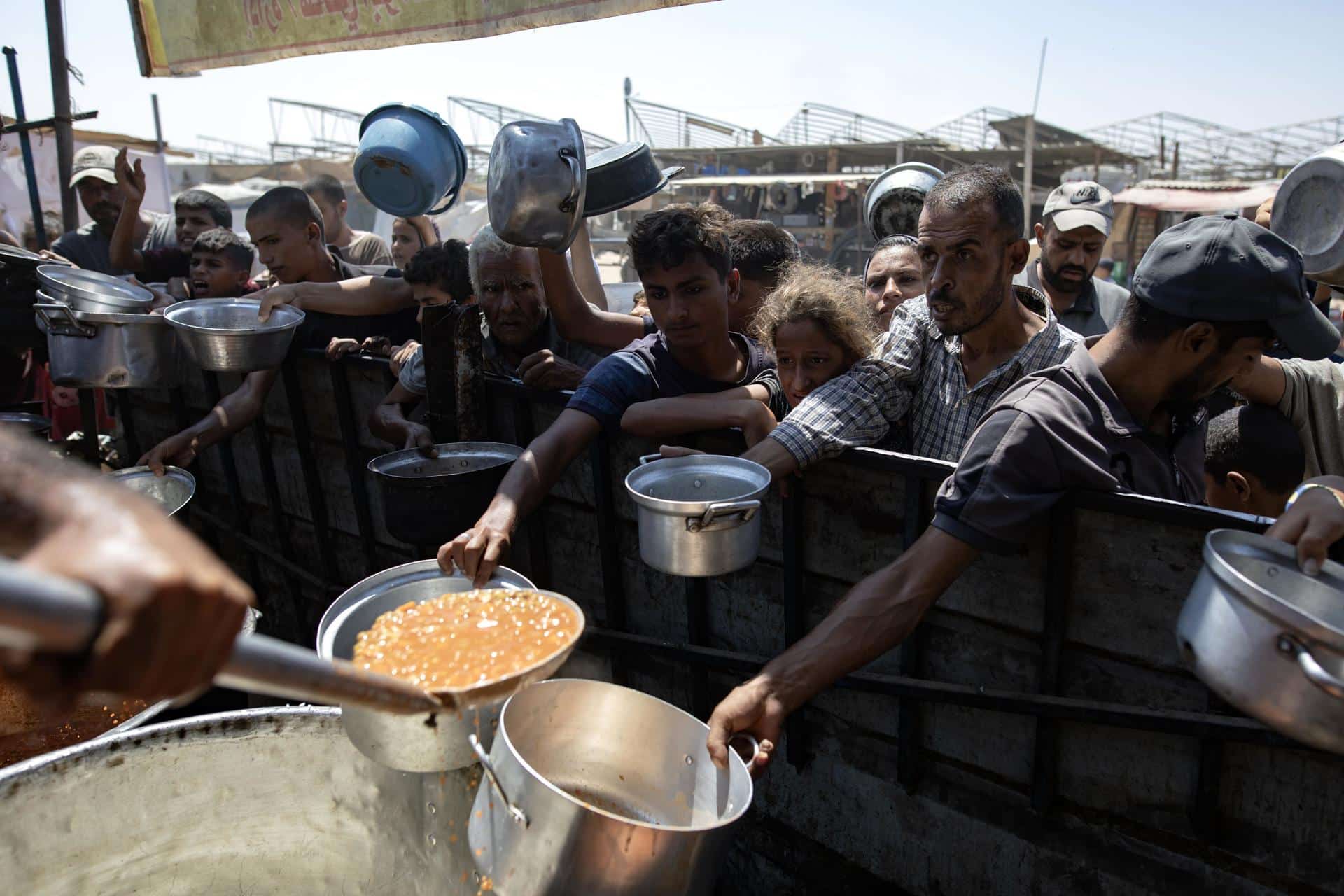 Fotografía de archivo de palestinos desplazados internos recibiendo alimentos donados. EFE/HAITHAM IMAD