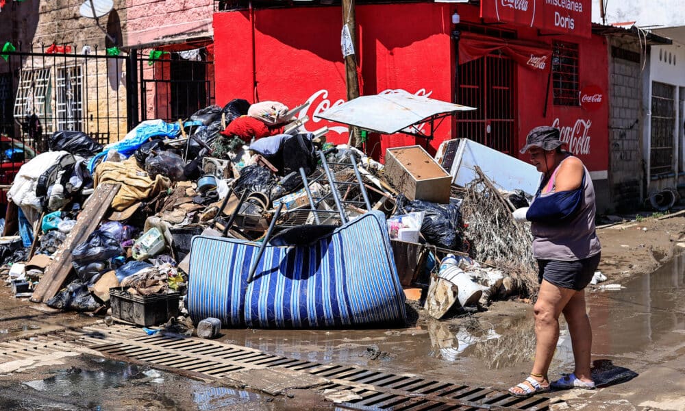 Una persona camina entre basura y enseres domésticos abandonados este lunes en las calles de la unidad habitacional Colosio, una de las más afectadas tras el paso del huracán John, en el balneario de Acapulco (México). EFE/David Guzmán