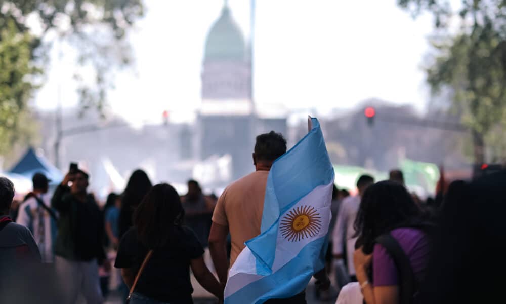 Un manifestante sostiene una bandera de Argentina en una marcha este miércoles en Buenos Aires (Argentina). EFE/ Juan Ignacio Roncoroni