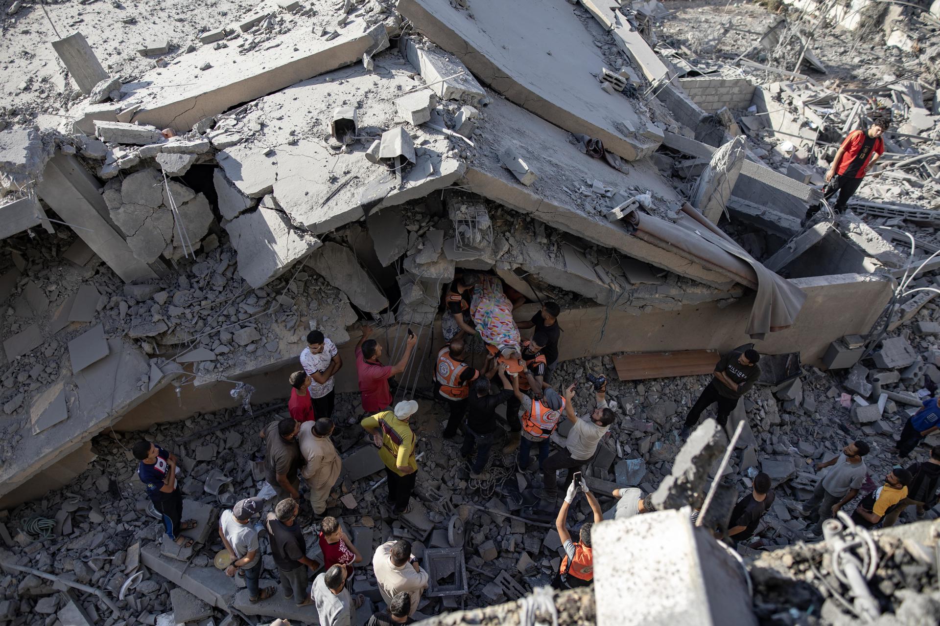 Palestinos recuperan un cadáver en el interior de un edificio destruído por bombardeos israelíes en Jan Yunis.EFE/EPA/Haitham Imad