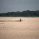 Un hombre camina en la arena a la orilla del río Solimões, este jueves en la región de Manacapuru, Amazonas (Brasil). EFE/ Raphael Alves