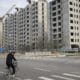 Fotografía de archivo de un hombre en bicicleta junto a un sitio de construcción en Pekín, China. EFE/ANDRÉS MARTÍNEZ CASARES