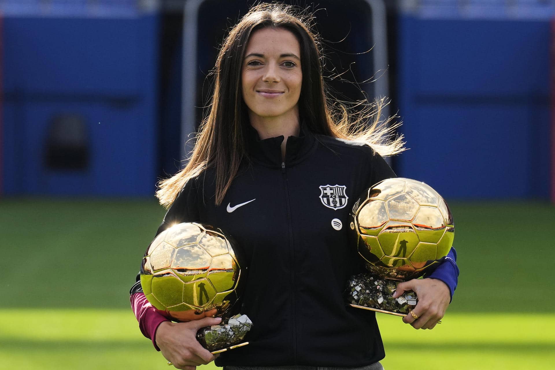 La centrocampista del Barcelona Aitana Bonmatí, que el pasado lunes fue galardonada por segunda vez con el Balón de Oro como mejor jugadora del mundo, posa con los dos trofeos antes de atender a los medios de comunicación este jueves en el estadio Johan Cruyff. EFE/Alejandro García