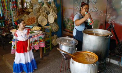 Personas preparan una sopa de vegetales, frijoles y maíz, durante la celebración del jopará, este martes en la Plaza Uruguaya, en Asunción (Paraguay). EFE/Juan Pablo Pino