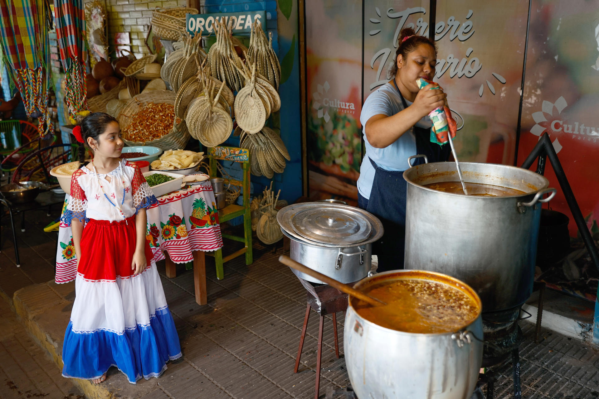 Personas preparan una sopa de vegetales, frijoles y maíz, durante la celebración del jopará, este martes en la Plaza Uruguaya, en Asunción (Paraguay). EFE/Juan Pablo Pino