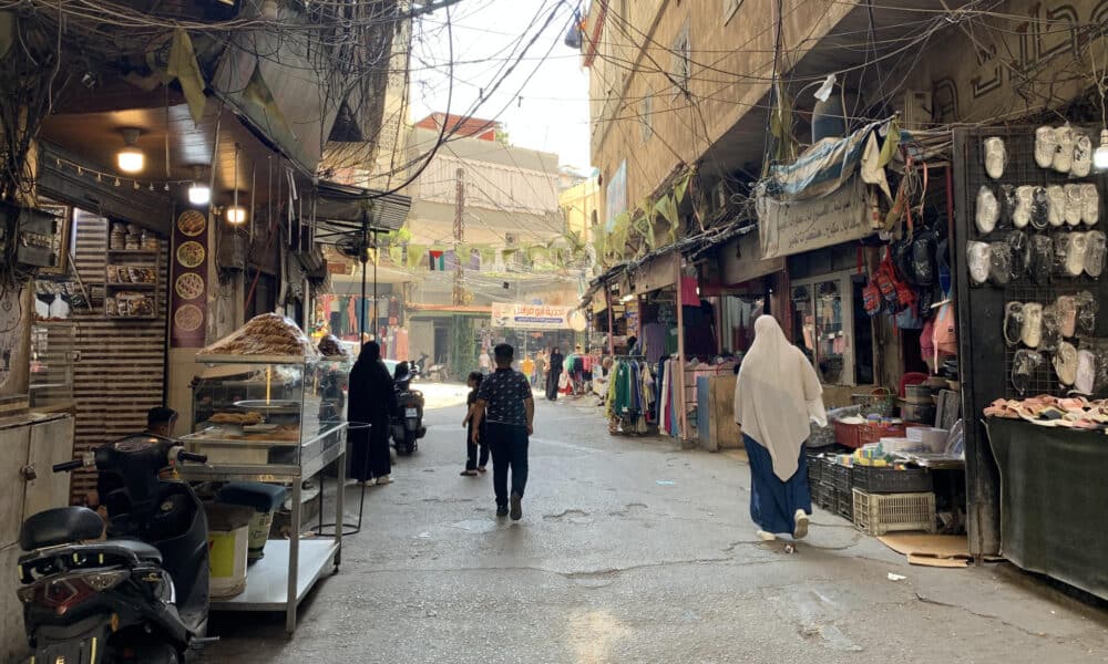 Transeúntes caminan por una calle del campo de refugiados palestinos de Beddawi, en el norte del Líbano, este miércoles. La población del campo de refugiados palestinos de Beddawi no se esperaba que sus laberínticas callejuelas copadas por marañas de cables eléctricos fuesen a ser objetivo de un bombardeo israelí como el del pasado sábado, el primero en el norte del Líbano en un año de violencia. EFE/ Noemí Jabois