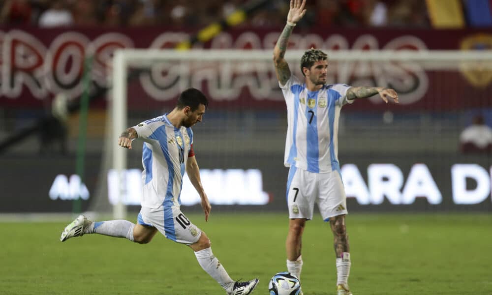 Lionel Messi patea un tiro libre junto a Rodrigo de Paul en el partido de las eliminatorias sudamericanas ante Venezuela en el estadio Monumental de Maturín. EFE/ Ronald Peña R.