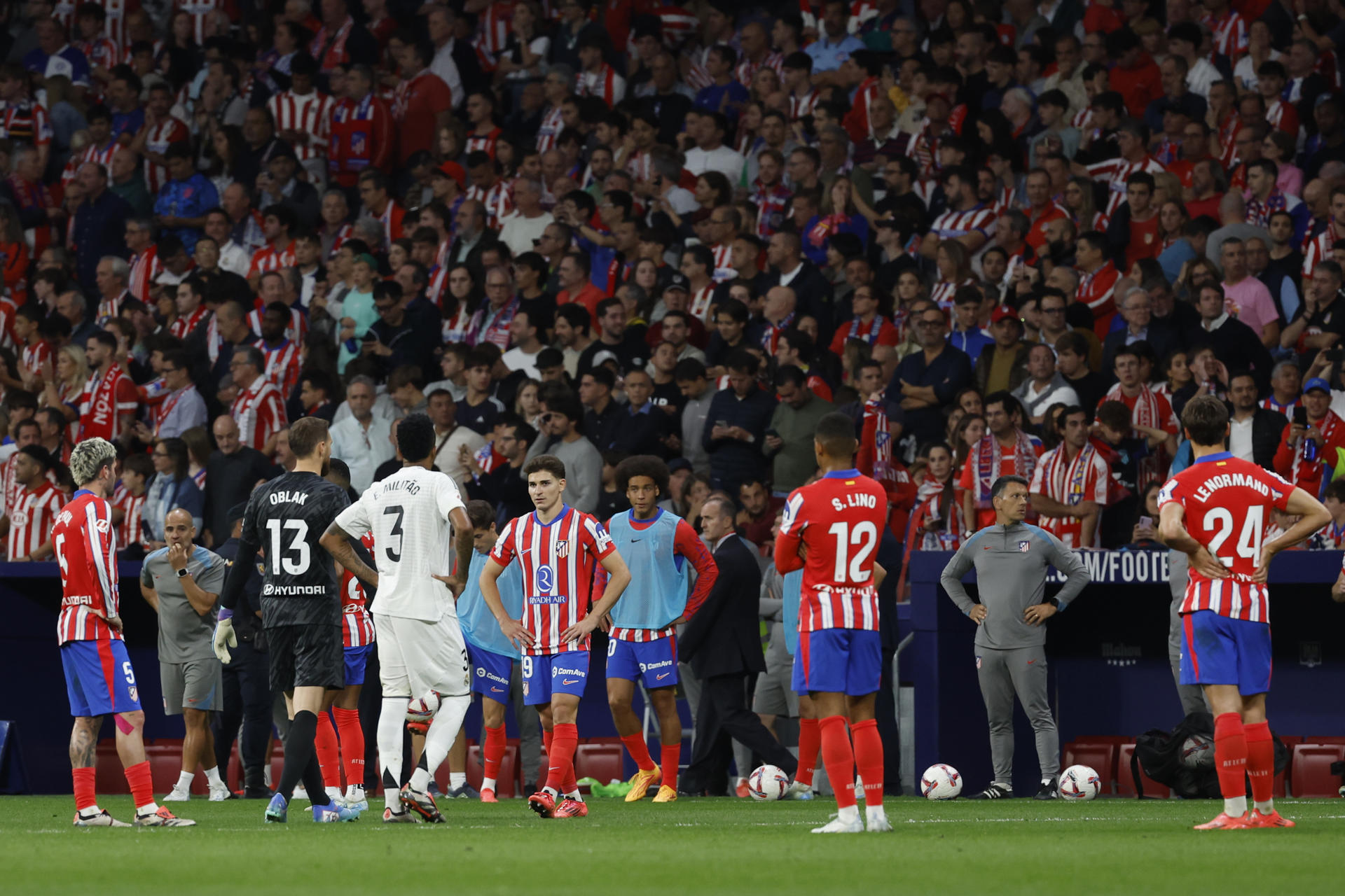 Jugadores del Atlético y del Real Madrid durante el parón en el partido de la LaLiga EA Sports que Atlético de Madrid y Real Madrid disputaron en el estadio Civitas Metropolitano. EFE/JJ Guillén