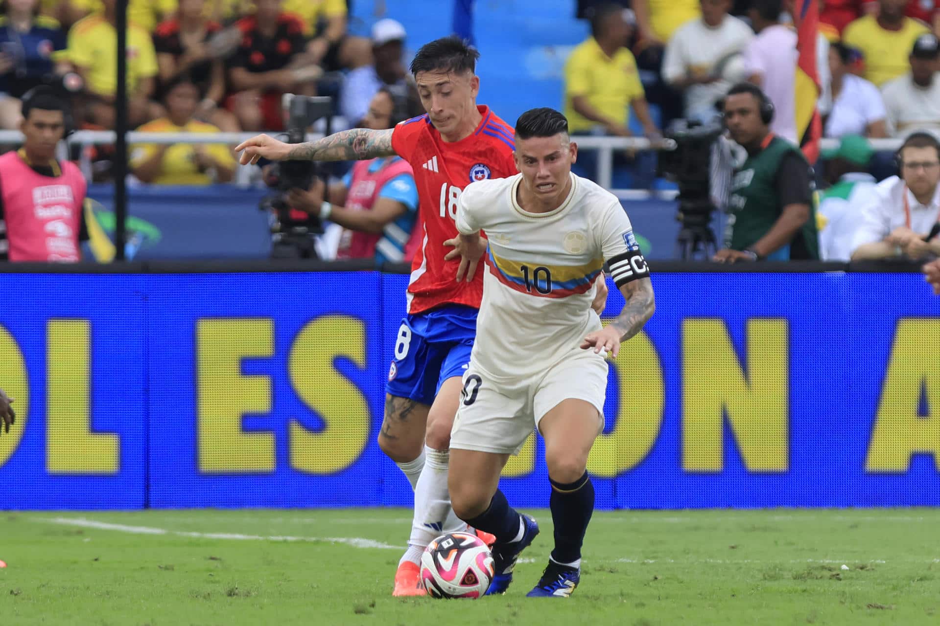 James Rodríguez (d) disputa el balón con el chileno Rodrigo Echeverría este martes, en un partido de las eliminatorias sudamericanas al Mundial de 2026, en el estadio Metropolitano de Barranquilla, Colombia. EFE/ Ricardo Maldonado Rozo