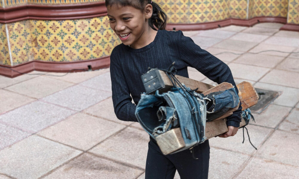 Una niña camina con unos zancos en sus manos, durante una presentación musical de la organización social Coincidir, este viernes en el Palacio Nacional de la Cultura, de la Ciudad de Guatemala (Guatemala). Durante los primeros 10 meses de 2024, 43.025 niñas y adolescentes de Guatemala, entre los 11 y 19 años, se han convertido en madres, de acuerdo con los registros divulgados este viernes por organizaciones sociales en el marco del Día Internacional de la Niña. EFE/ David Toro