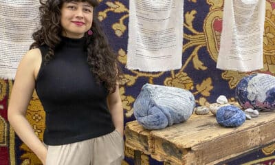 La artista colombiana Vanessa Nieto posa junto a una de sus obras expuestas en la Real Fábrica de Tapices, en el marco de la exposición 'Reencuentros para tejer la vida y los afectos'. EFE/Patricia Cotelo Bertaiola