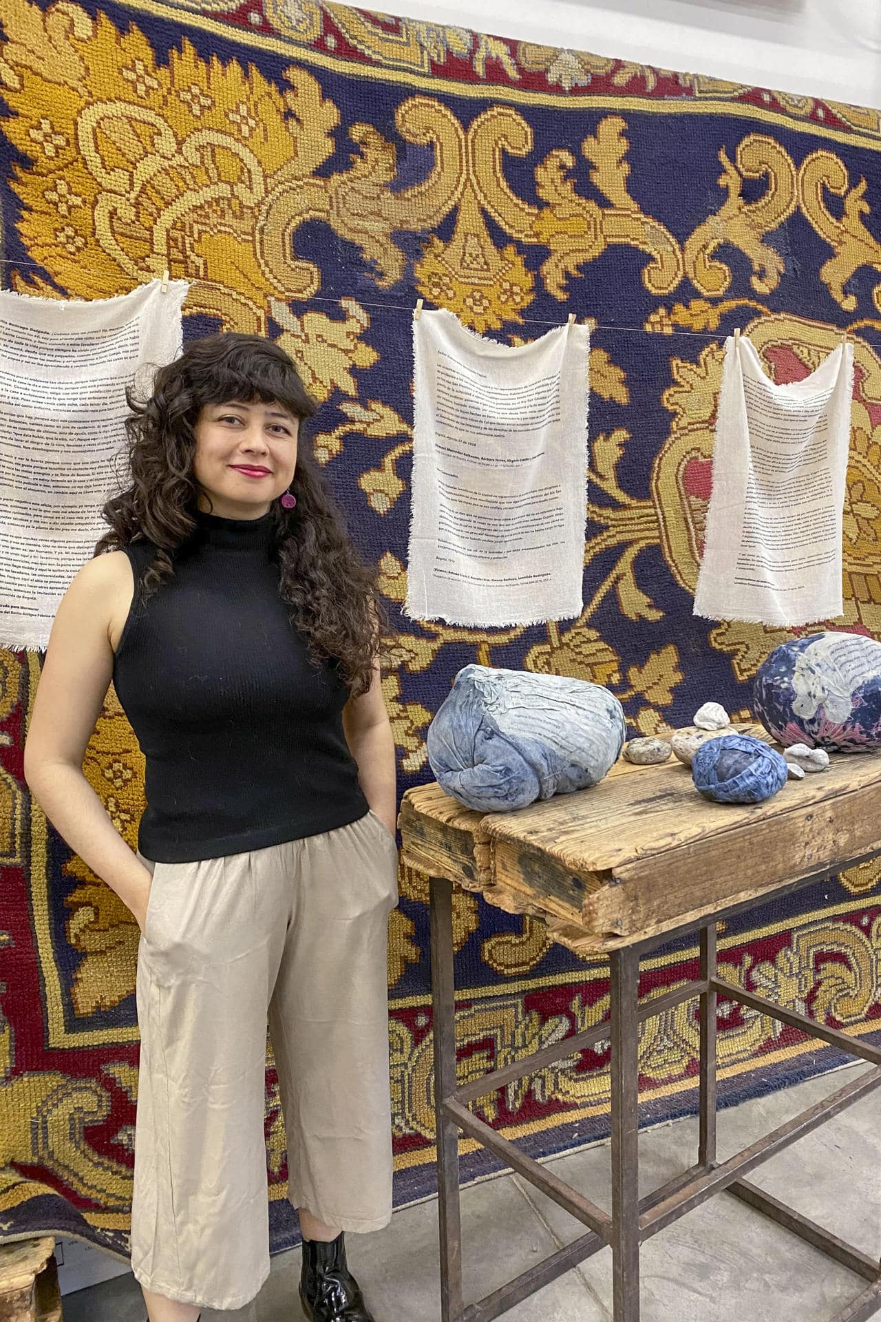 La artista colombiana Vanessa Nieto posa junto a una de sus obras expuestas en la Real Fábrica de Tapices, en el marco de la exposición 'Reencuentros para tejer la vida y los afectos'. EFE/Patricia Cotelo Bertaiola