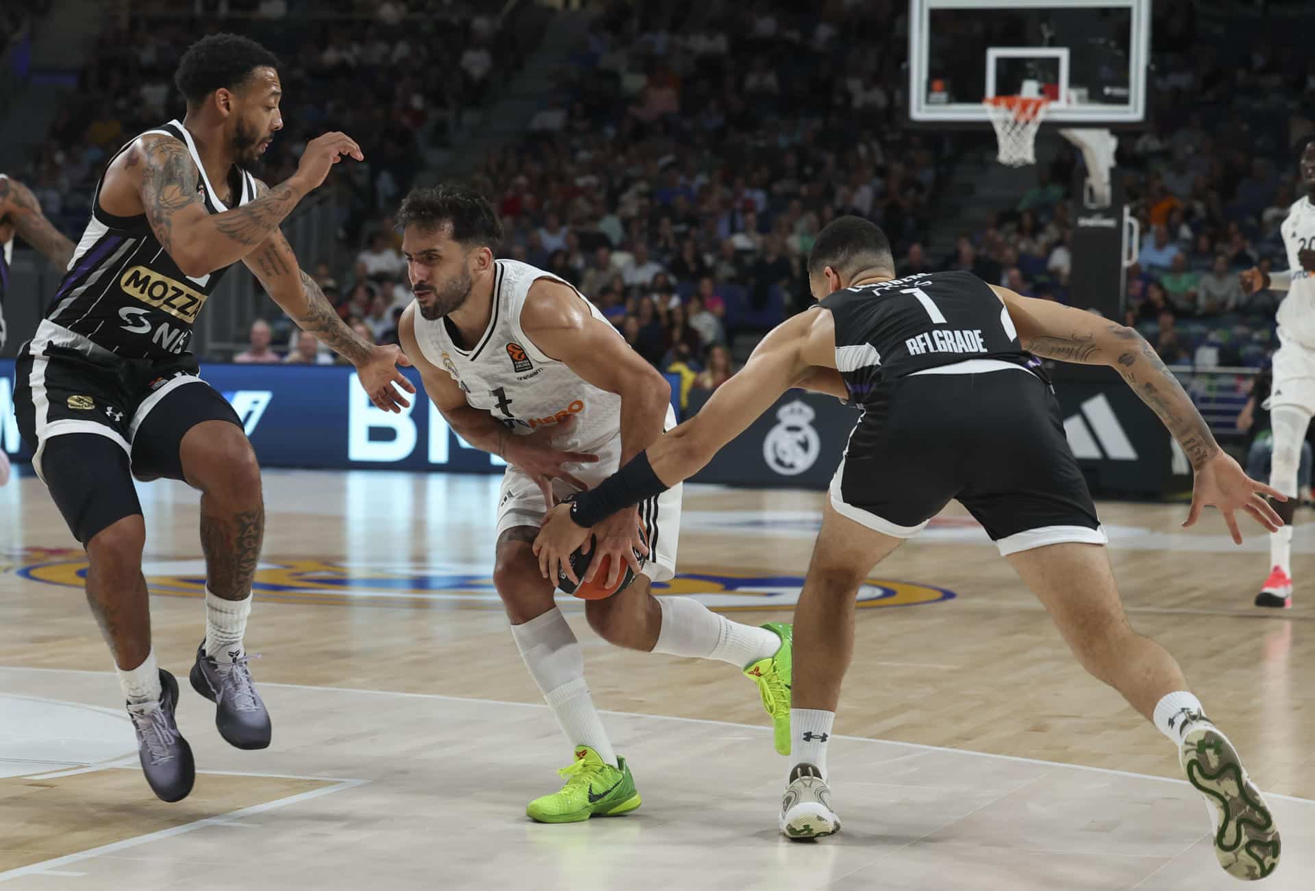 El base del Real Madrid Facundo Campazzo (c) lucha con el escolta danés del Partizan "Iffe" Lundberg (d) durante el encuentro de Euroliga que el argentino pudo jugar gracias a la suspensión cautelar de la sanción que ha confirmado el Comité de Apelación de la competición. EFE/ Kiko Huesca