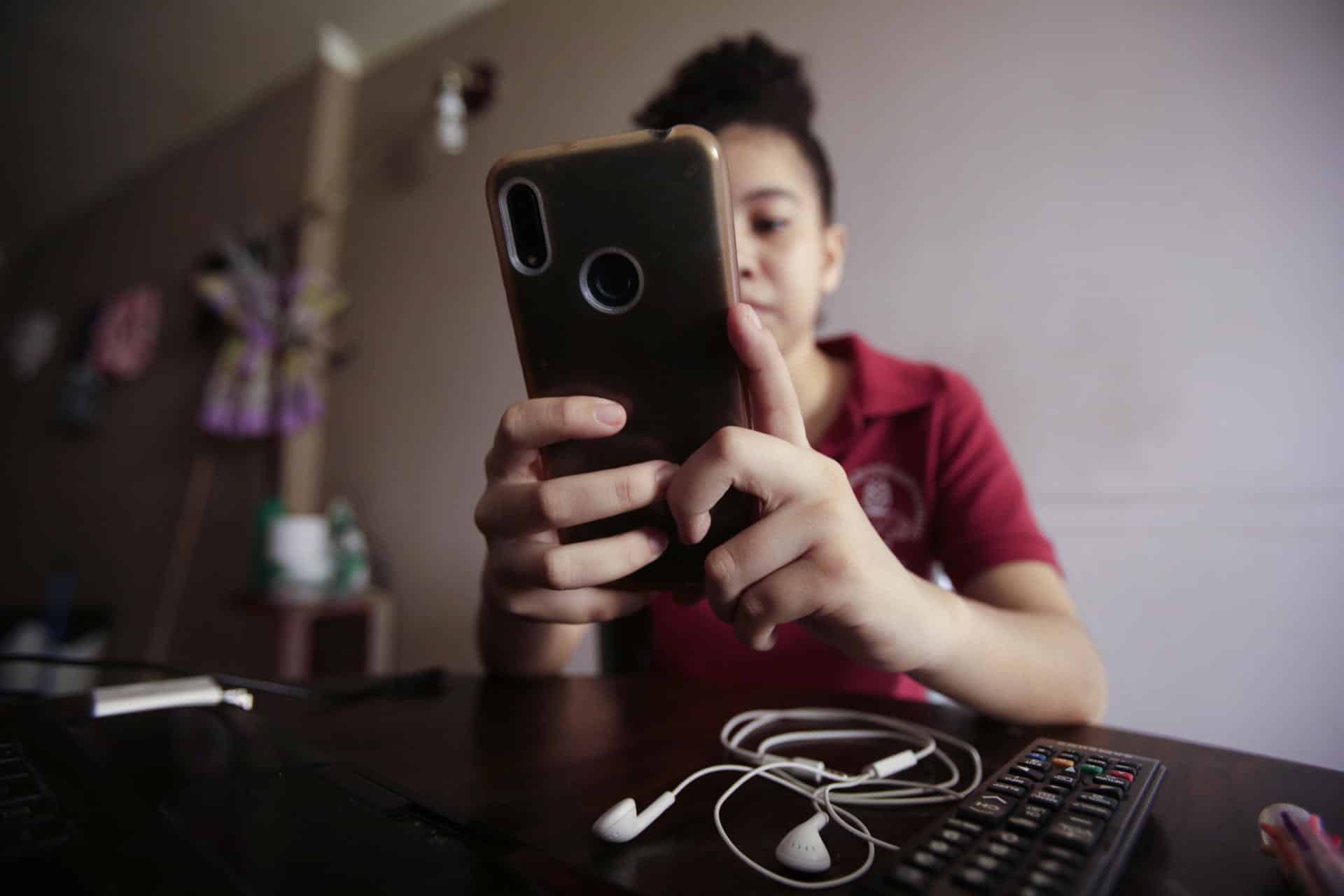 Fotografía de archivo de una niña que manipula un teléfono celular. EFE/ Carlos Lemos